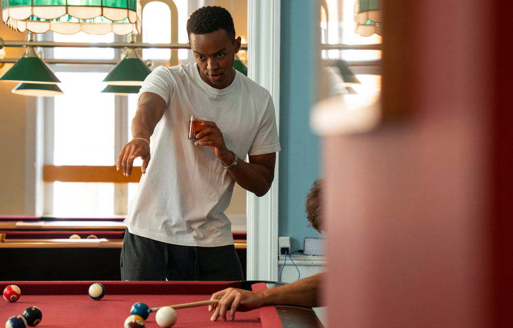 Man playing pool with an alcohol-free drink in his hand